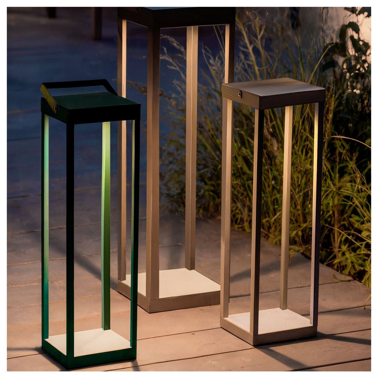 Tre lamper av modellen Sollerön i stilren design på en treterrasse.