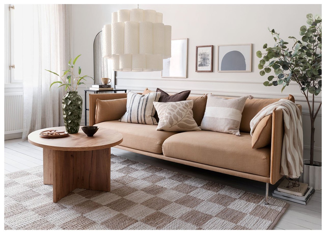 Soverom med lysebrun sofa, tekstiler i beige og brunt og et juteteppe med rutemønster i beige og lysebrunt.