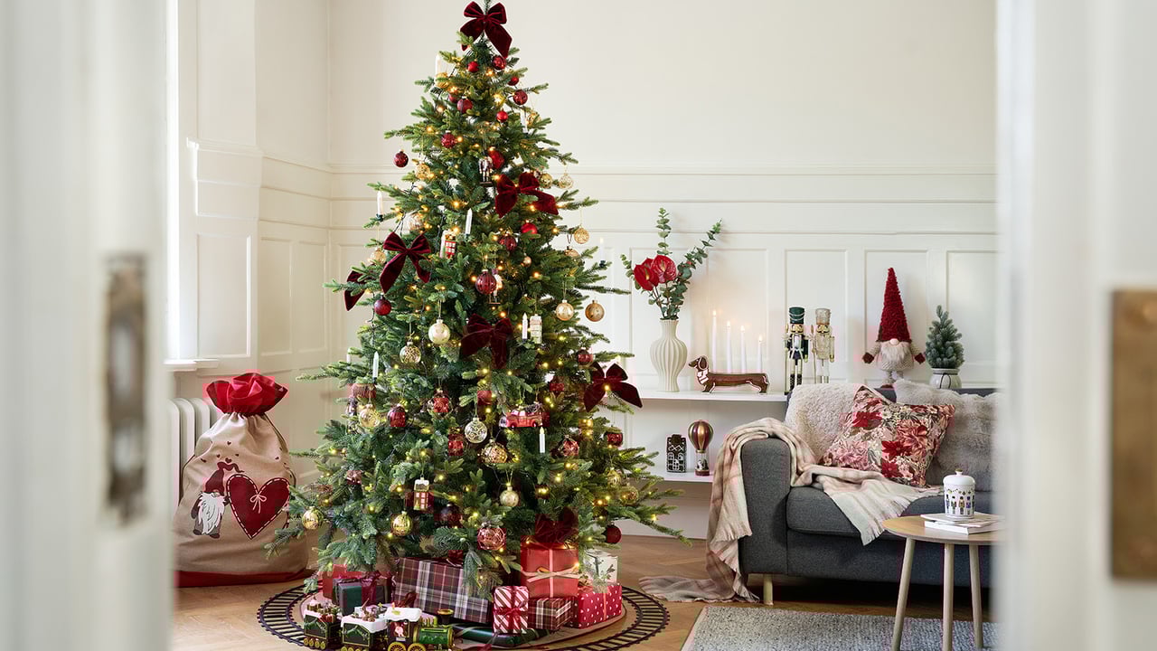 Weihnachtlich dekoriertes Wohnzimmer mit Baum, Geschenken und Dekorationen für eine stimmungsvolle und einladende Weihnachtsatmosphäre.