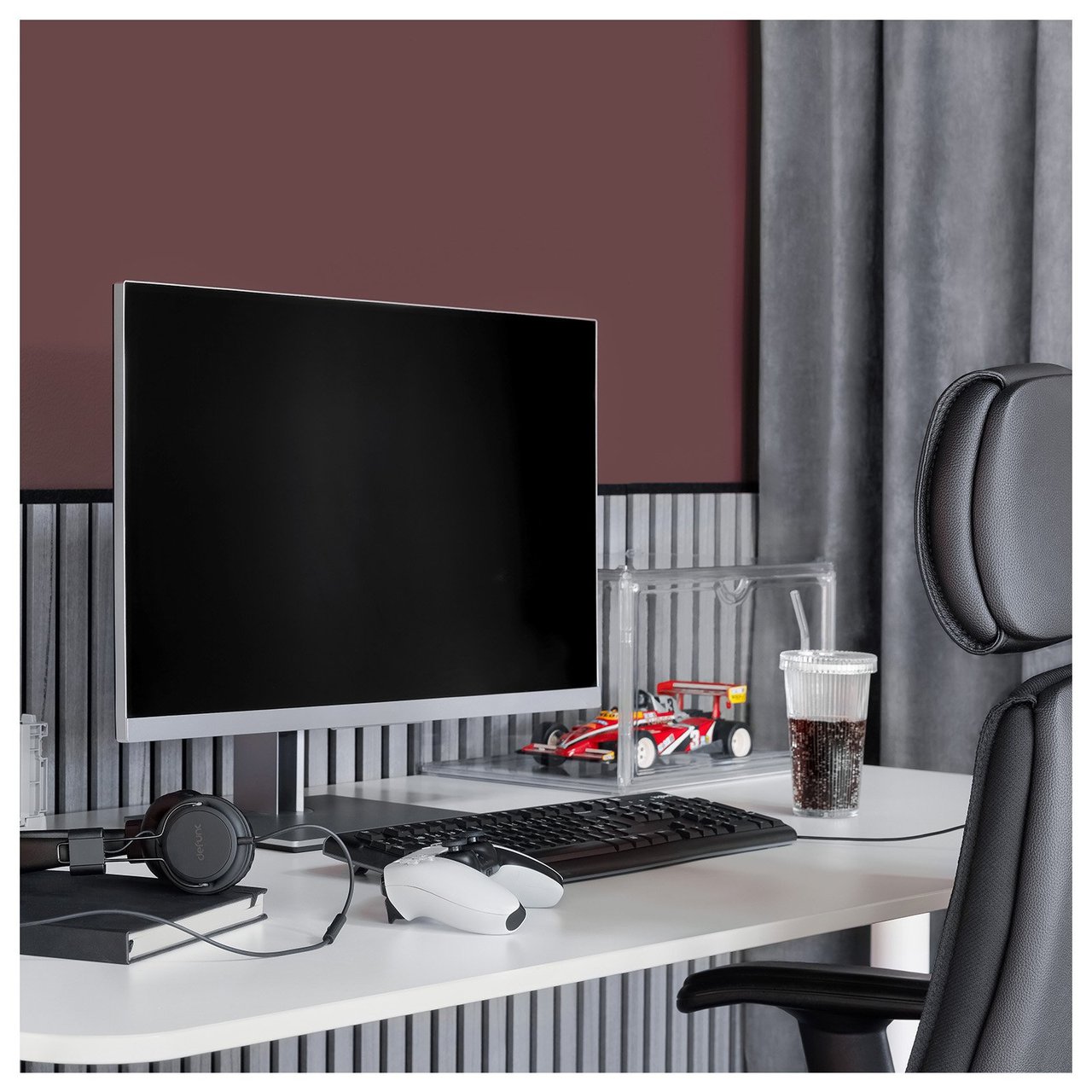 Gaminghörna med datorskärm på ett skrivbord. Akustikpanel har monterats bakom skrivbordet som en bröstpanel.