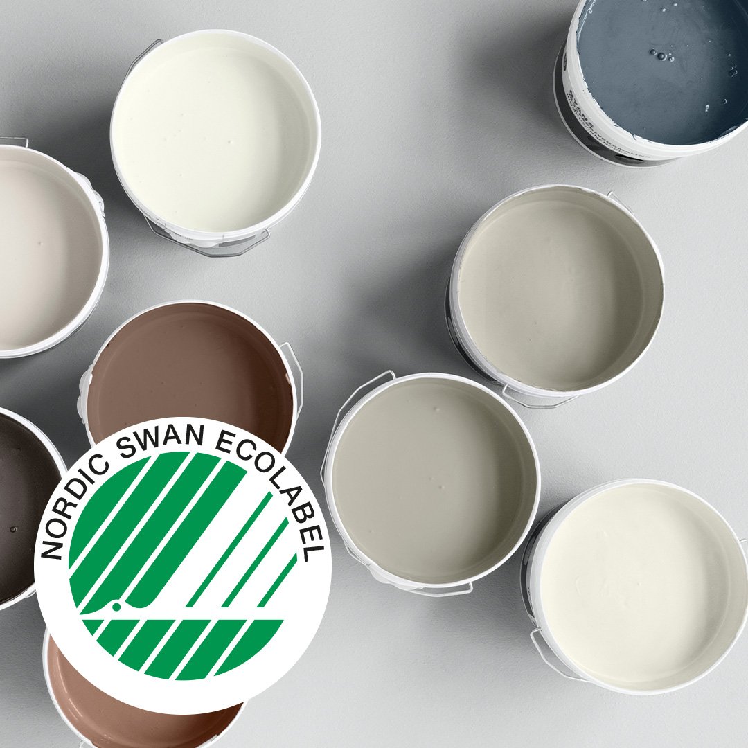 Svanenmärket tillsammans med flera öppna målarburkar med väggfärg i olika färger.