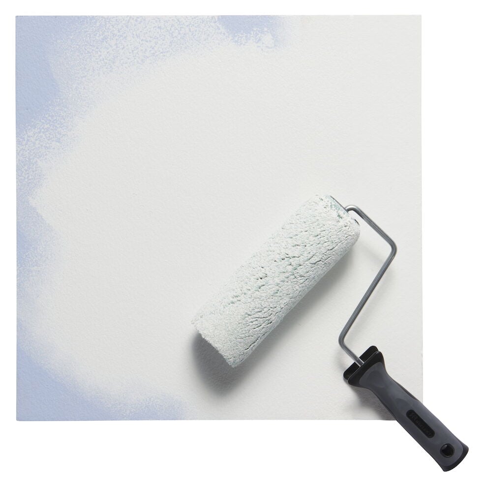 Vit väggfärg appliceras med svart målarroller.