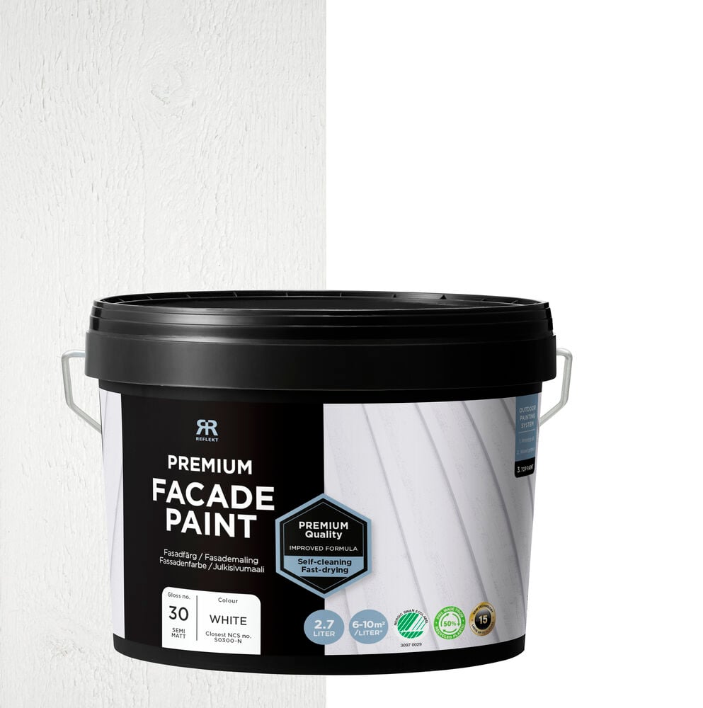 Svart hink med vit fasadfärg framför vägg.