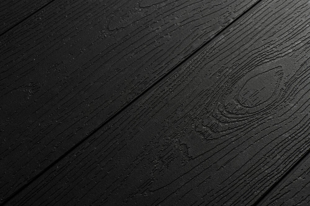 Svart bordsskiva med träliknande mönster och struktur.