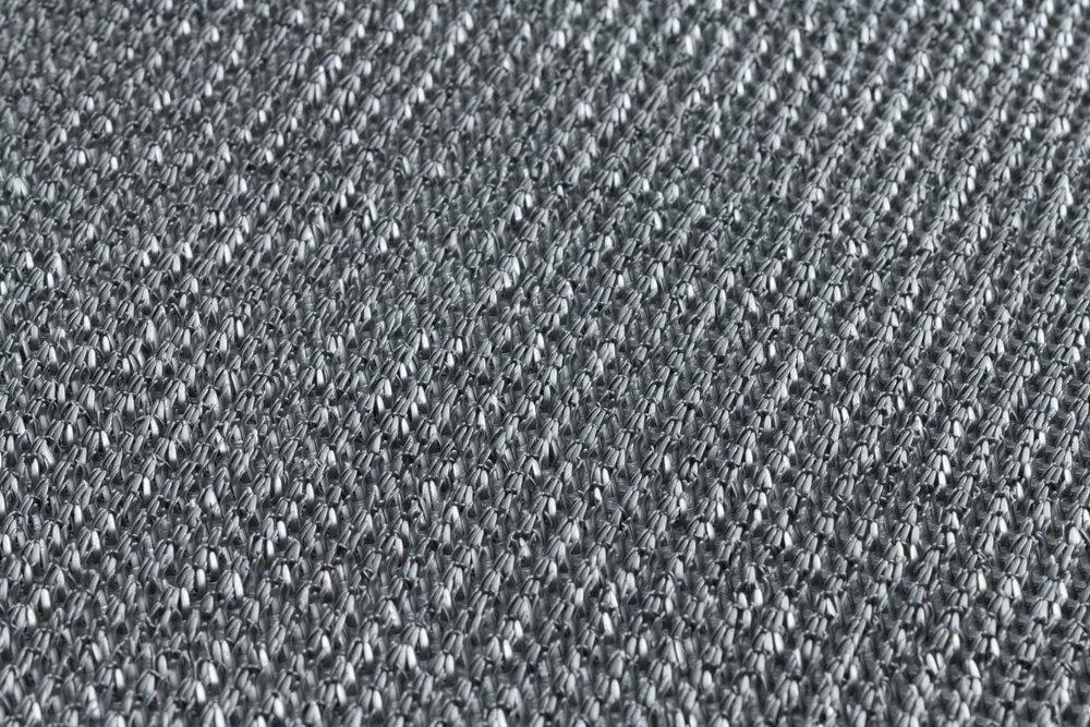 Lähikuva harmaasta kudotusta polypropeenitekstiilitakapuolesta.
