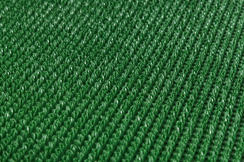 Keinotekoinen nurmikko, jossa on tiheä, tasainen ja vihreä pinta.