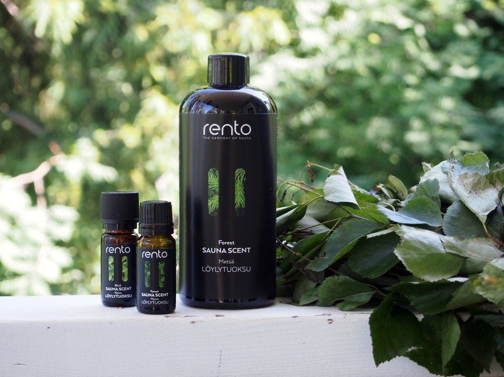 Kaksi pientä ja yksi iso musta saunatuoksupullo koivuvihdalla.