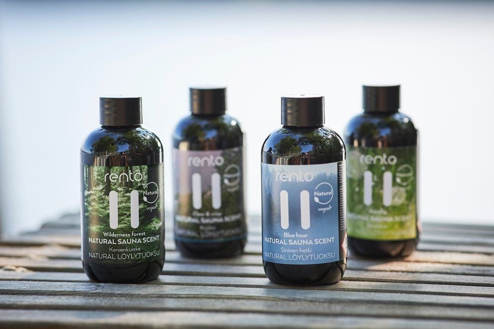 Neljä pulloa Renton saunatuoksua ulkona puupenkillä.