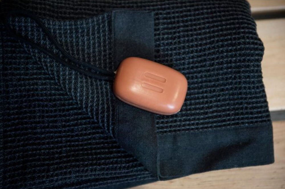 Ruskea saippua narulla mustalla pyyhkeellä.