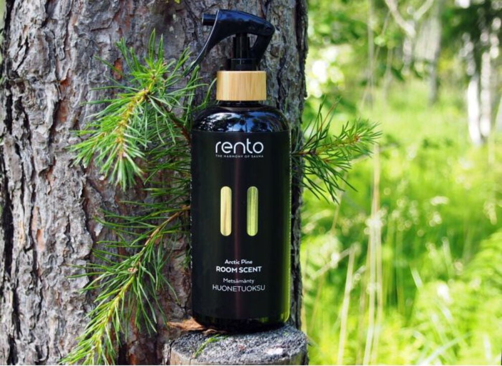 Musta suihkepullon huonetuoksu nojaten männyrunkoa vasten.