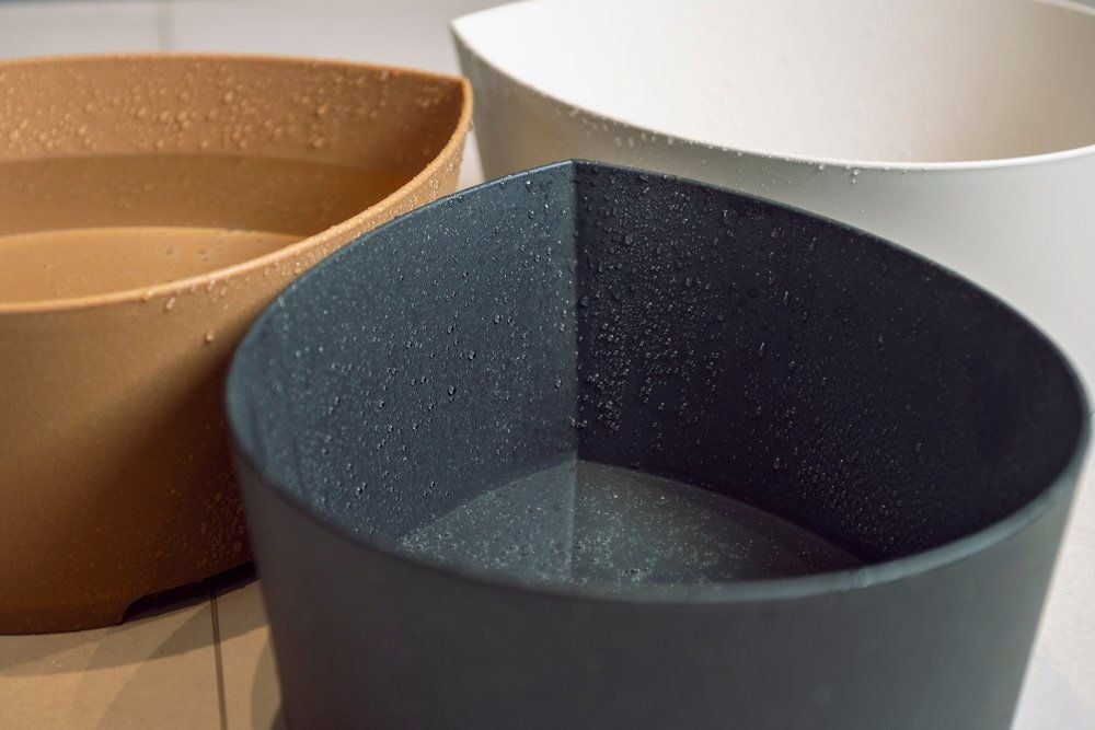 Kolme vesipisaran muotoista pesuallasta eri väreissä vedellä.