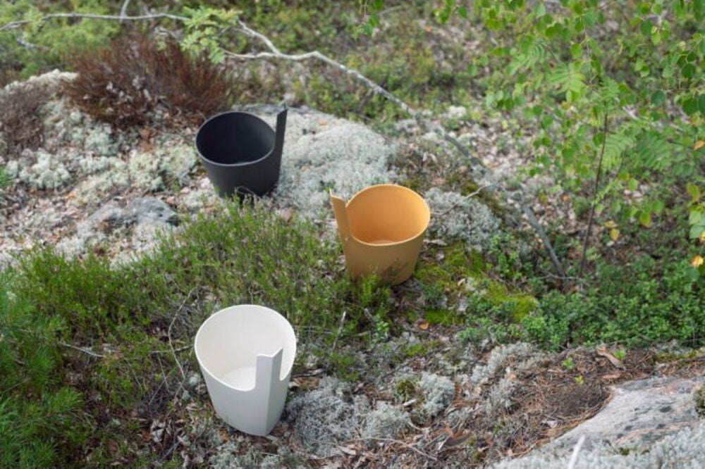 Kolme saaviämpäriä eri väreissä sammalmatolla.