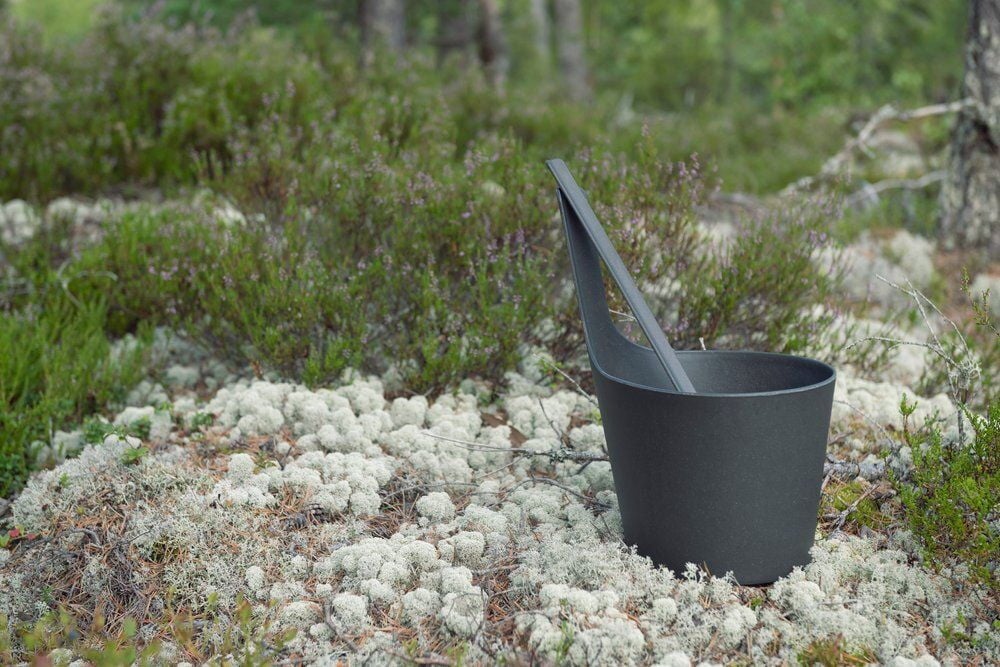 Musta saunasanko kahvalla seisoo ulkona luonnossa.