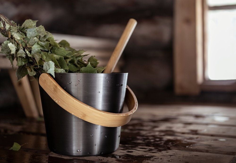 Musta alumiininen saunakiulu bambukahvalla.