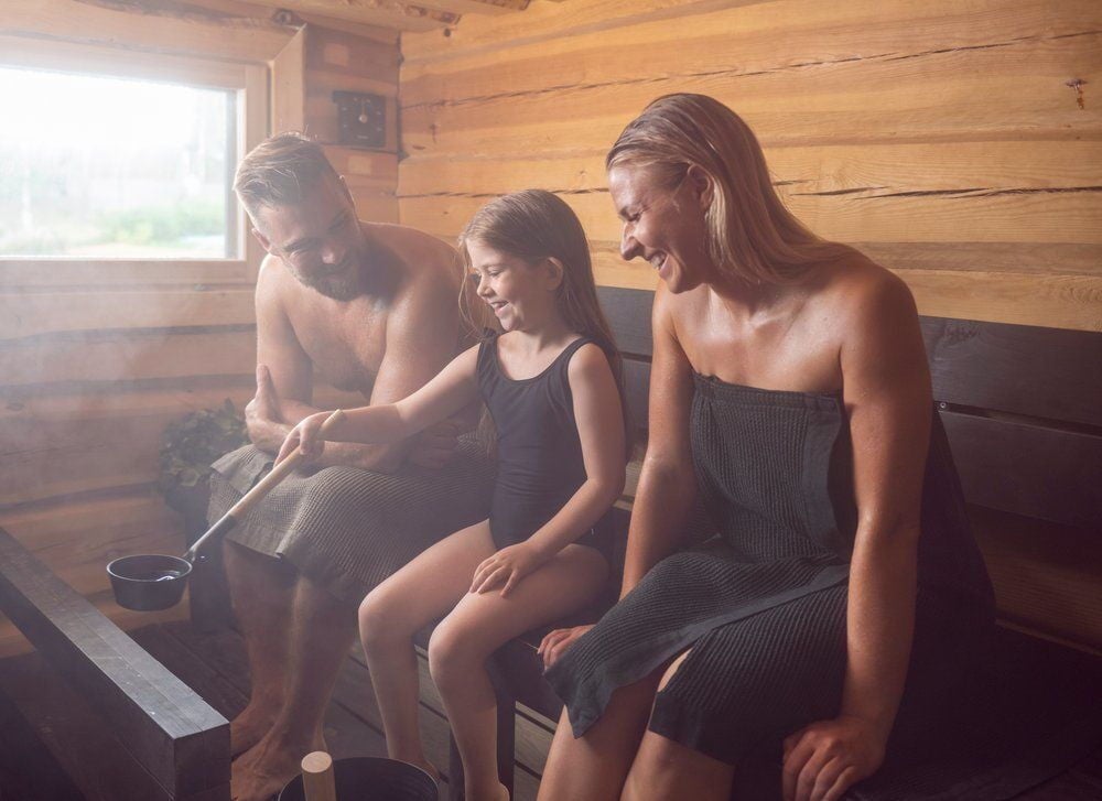 Perhe saunassa alumiinisella saunakauhalla.