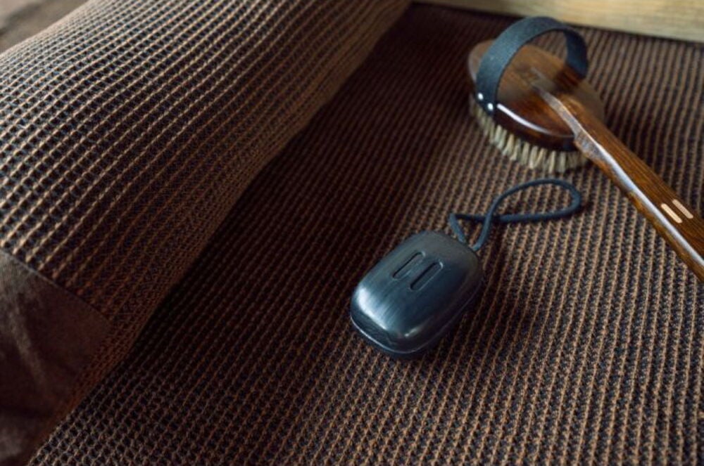 Ruskea pesuharja kahvalla ruskealla pyyhkeellä.