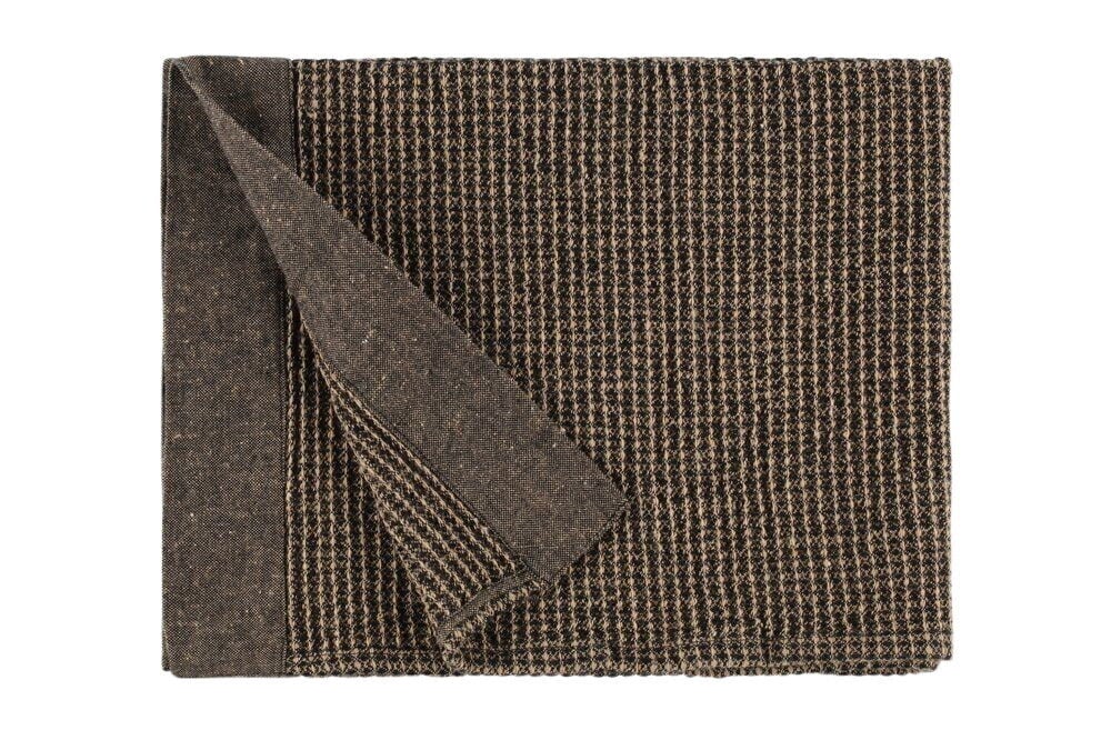 Musta ja beige saunapyyhe taitetuilla kulmilla.