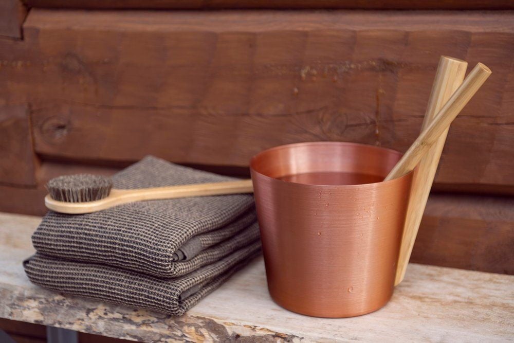 Taittaa saunapyyhkeet puuharjalla ja kuparikauhalla.