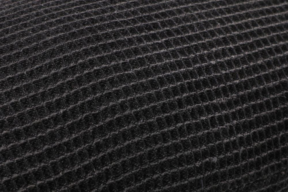 Lähikuva mustasta saunatyynystä, jossa on teksturoitu kangas.