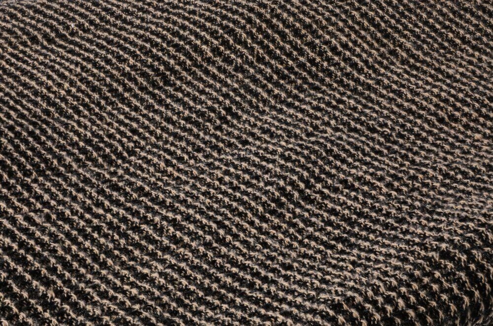 Lähikuva mustasta ja beigestä teksturoidusta kankaasta.