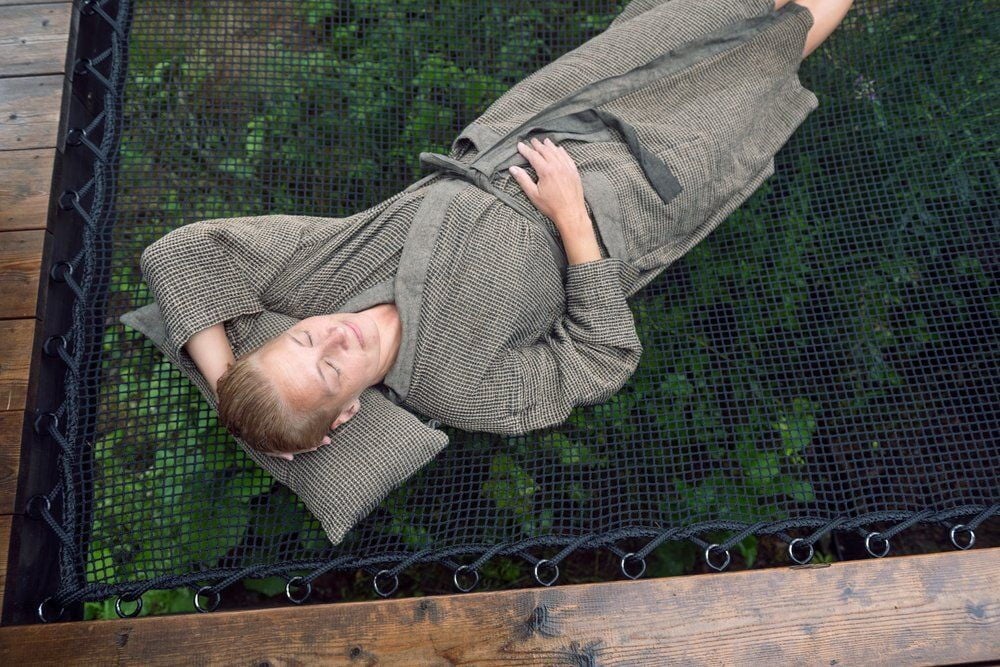 Henkilö makaa Rento Kenno saunatyynyllä ulkona.