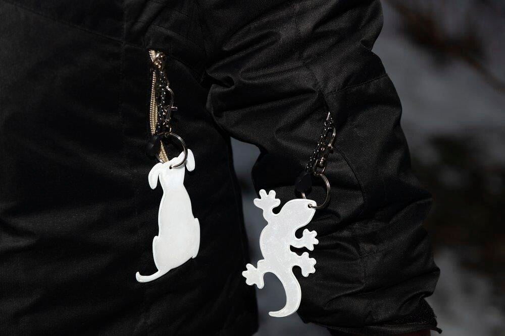 Kaksi heijastineläintä roikkuu takin avaimenperissä.