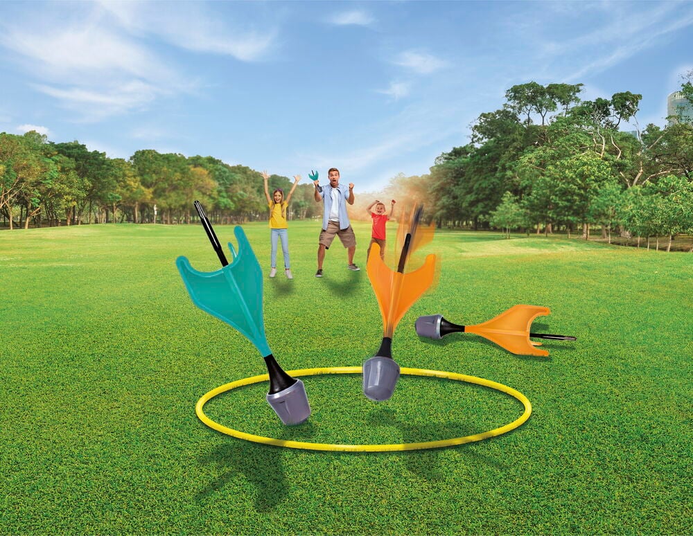 Lapset leikkivät tikkapeliä pehmeillä tikuilla ulkona.