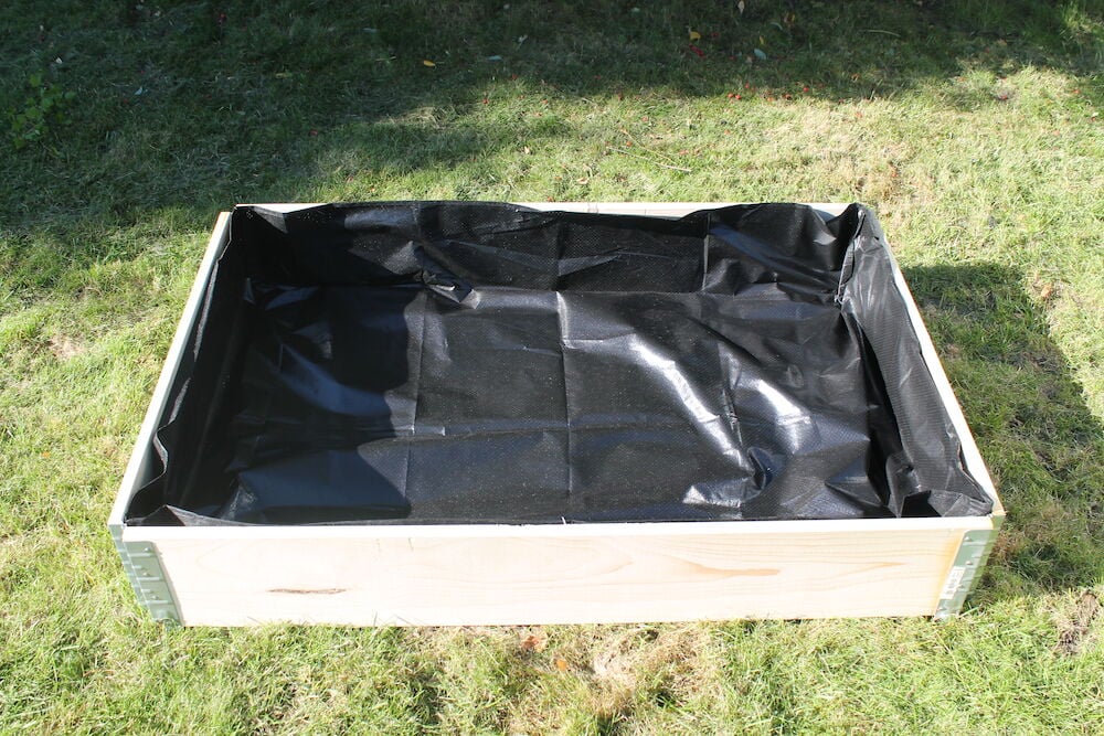 Musta alusta suorakulmaisessa lavakauluksessa nurmikolla.