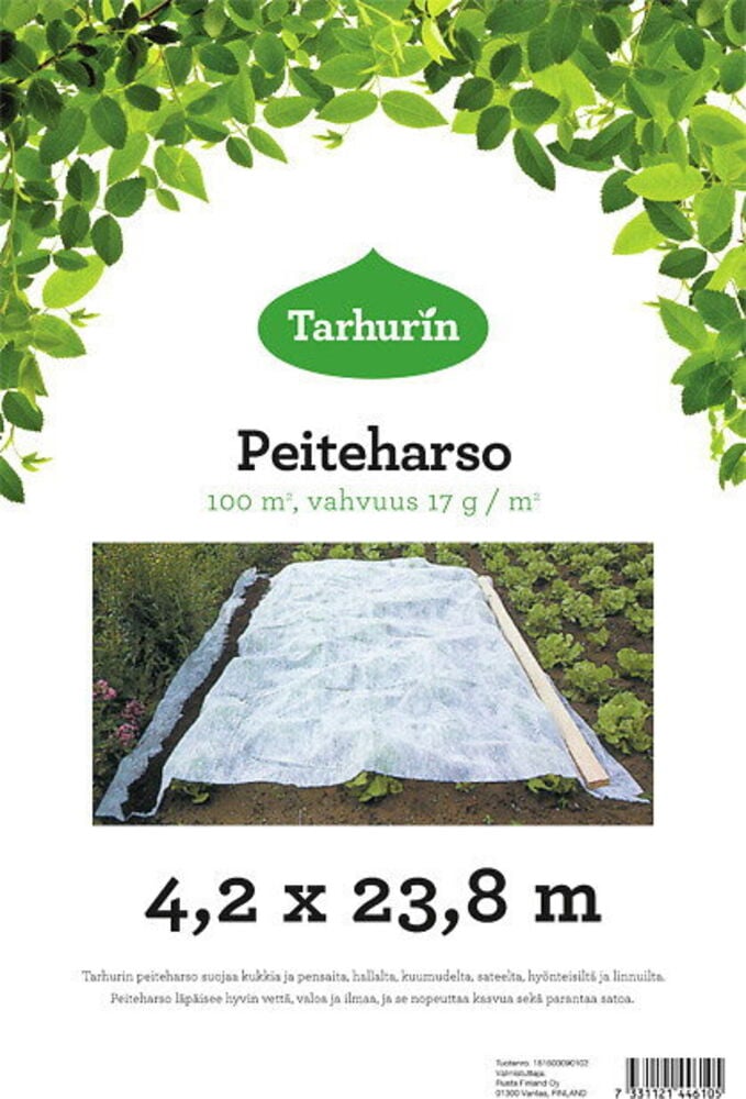 Valkoinen kuitukangas levitettynä istutusten päälle puutarhassa.