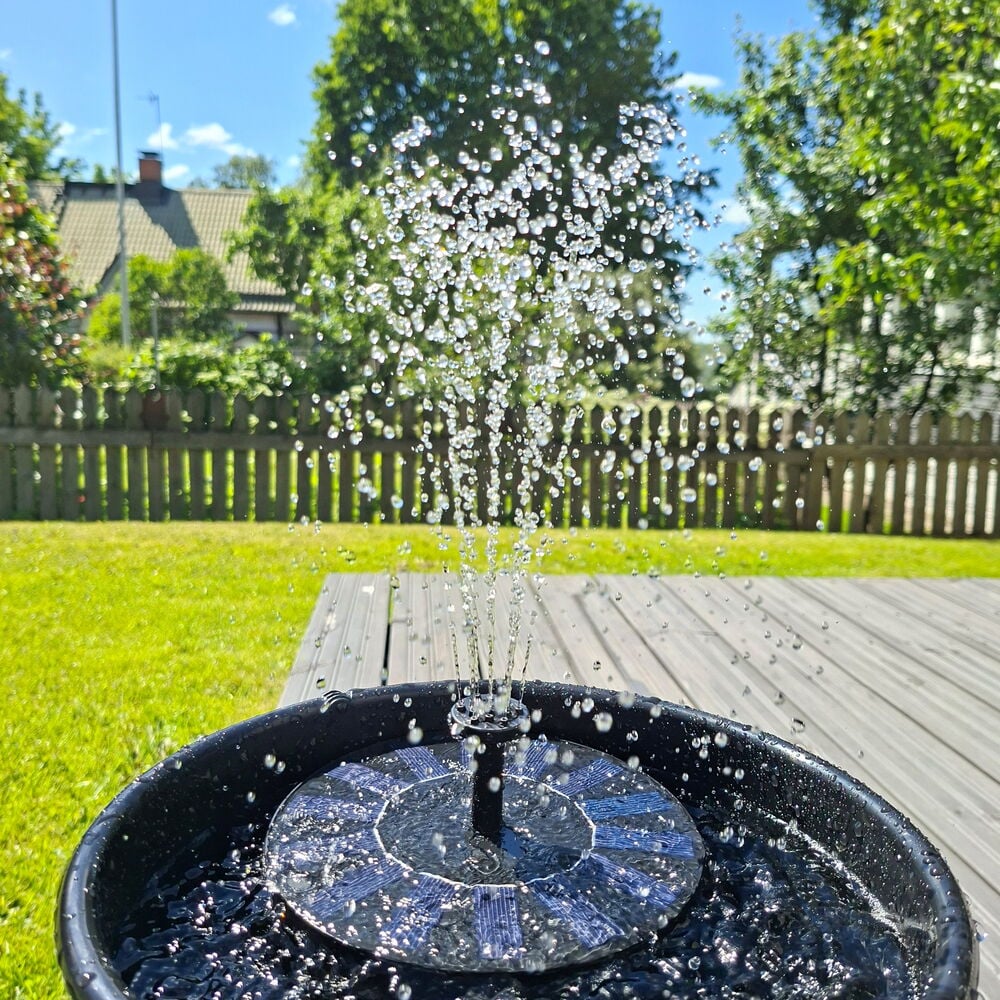 Suihkulähde aurinkokennolla Tarmo suihkuttaa vettä mustasta ruukusta aurinkoisena päivänä.