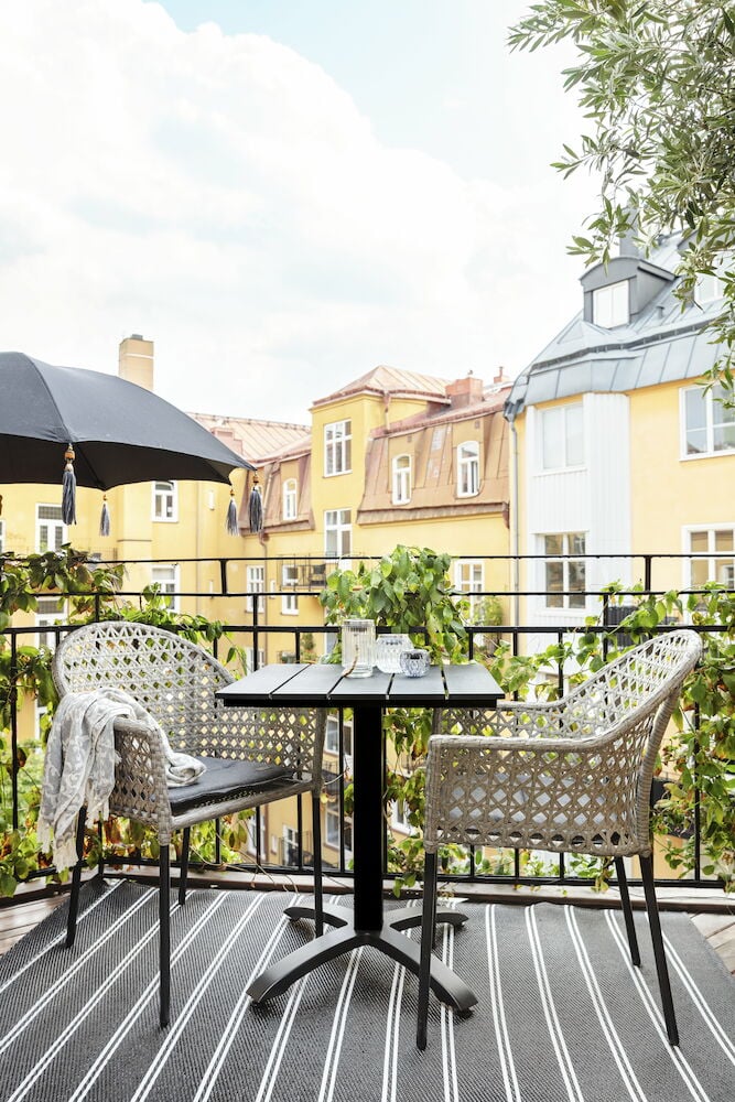 Musta kahvilapöytä ja kaksi tuolia parvekkeella.