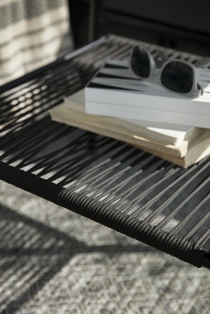 Musta pöytä, jolla on kirjoja ja aurinkolasit.