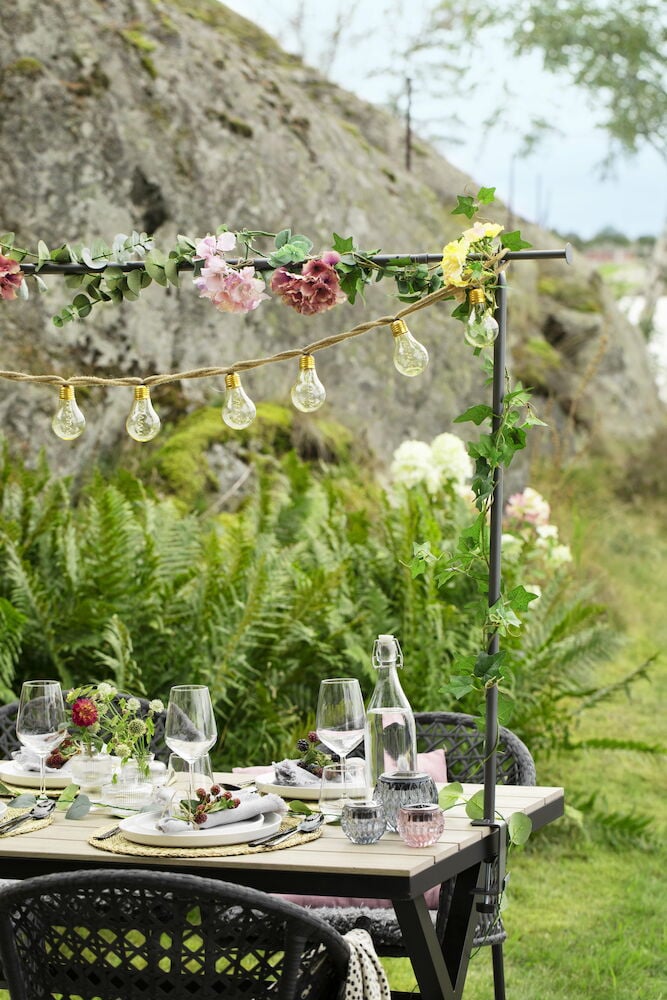 Valkoinen suorakulmainen ulkopöytä katettu illalliselle.