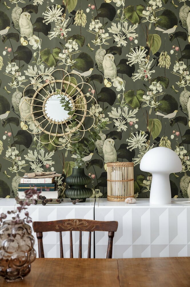 Vihreä kuviollinen tapetti, jossa on pöllöjä ja kasveja.