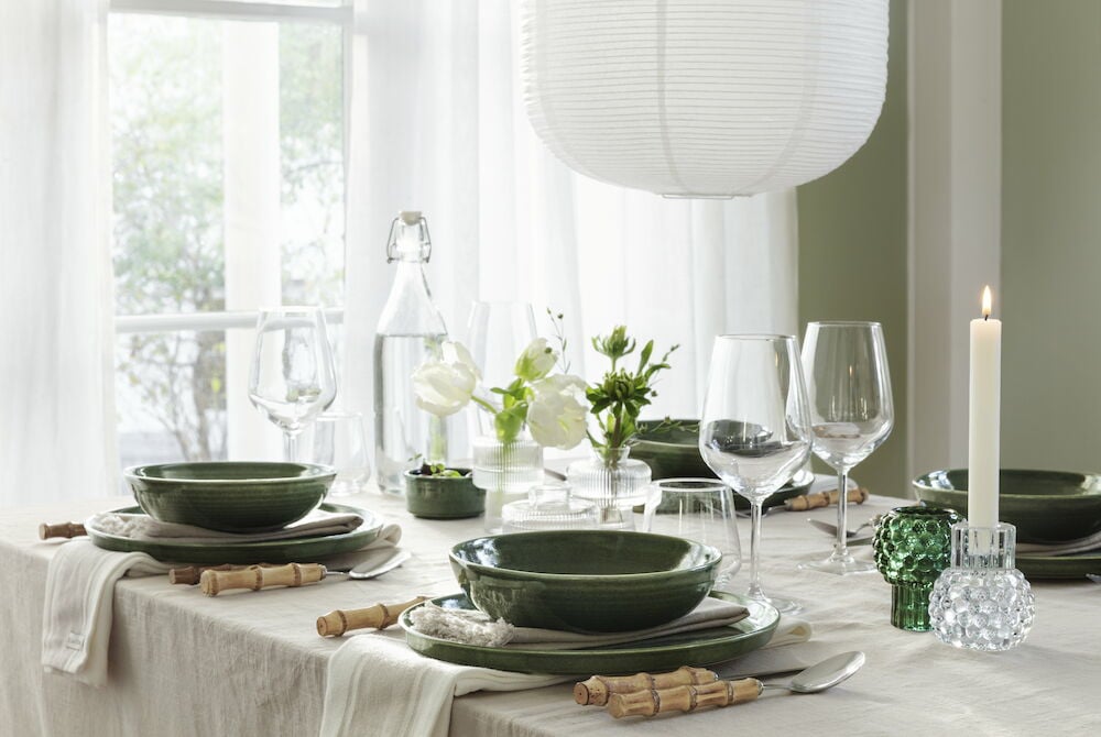 Beige puuvillaliina hapsuineen katetulla ruokapöydällä.