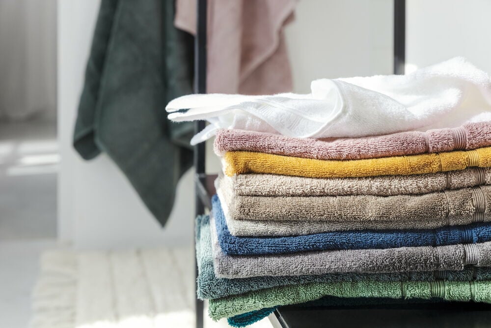 En stapel vikta handdukar i olika färger.