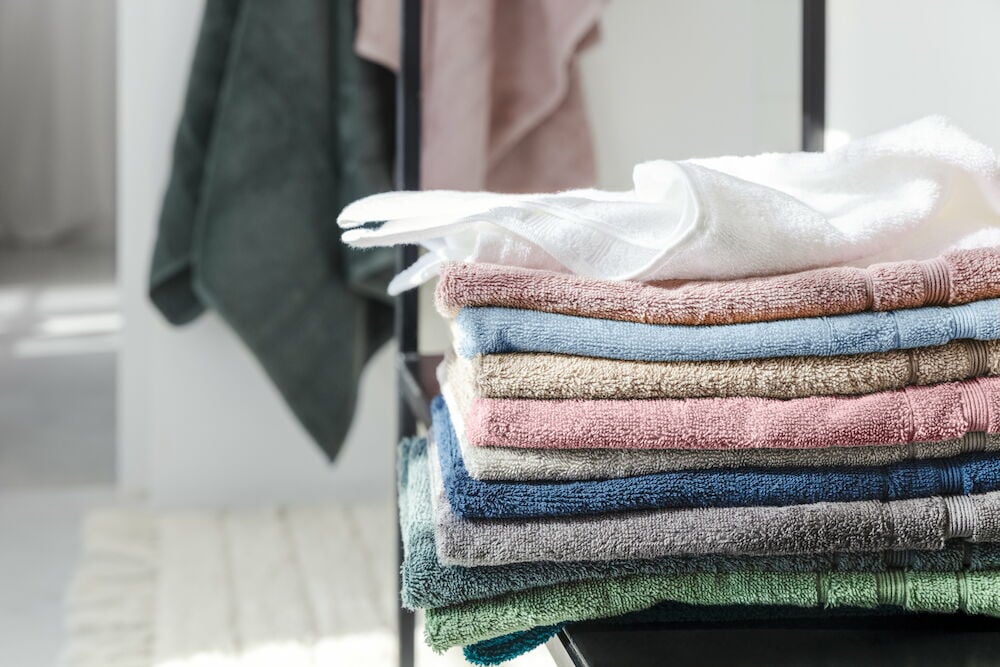 En stapel vikta handdukar i olika färger.