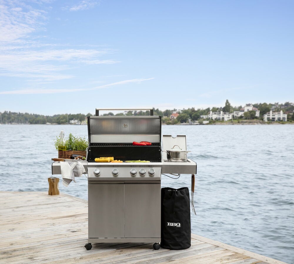 Svart överdrag på gasolflaska bredvid grill.