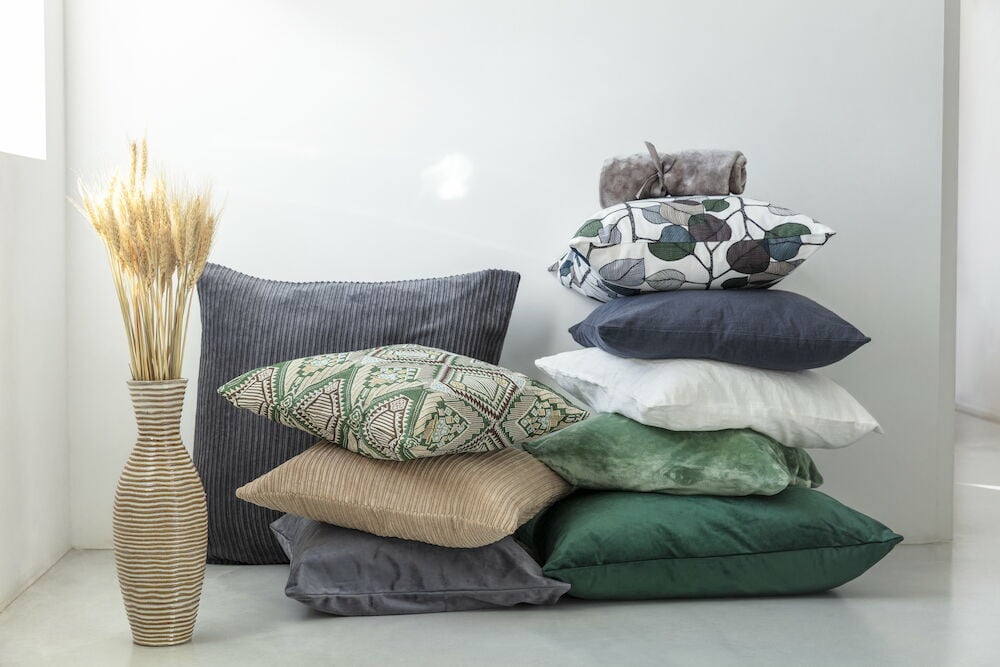 Mehrere Kissen und Kissenbezüge in verschiedenen Farben und Mustern.