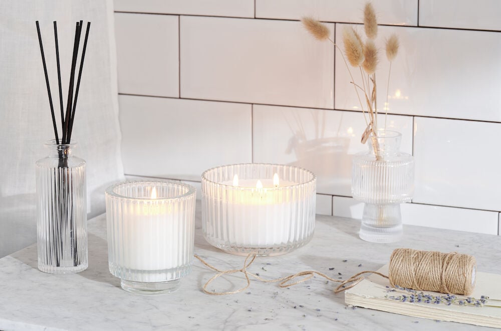 Doftpinnar och ljus på marmorbord i kök.