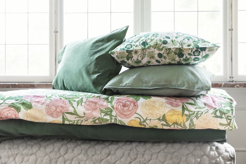 Vihreä pussilakanasetti, jossa on puuvillaiset tyynyliinat.