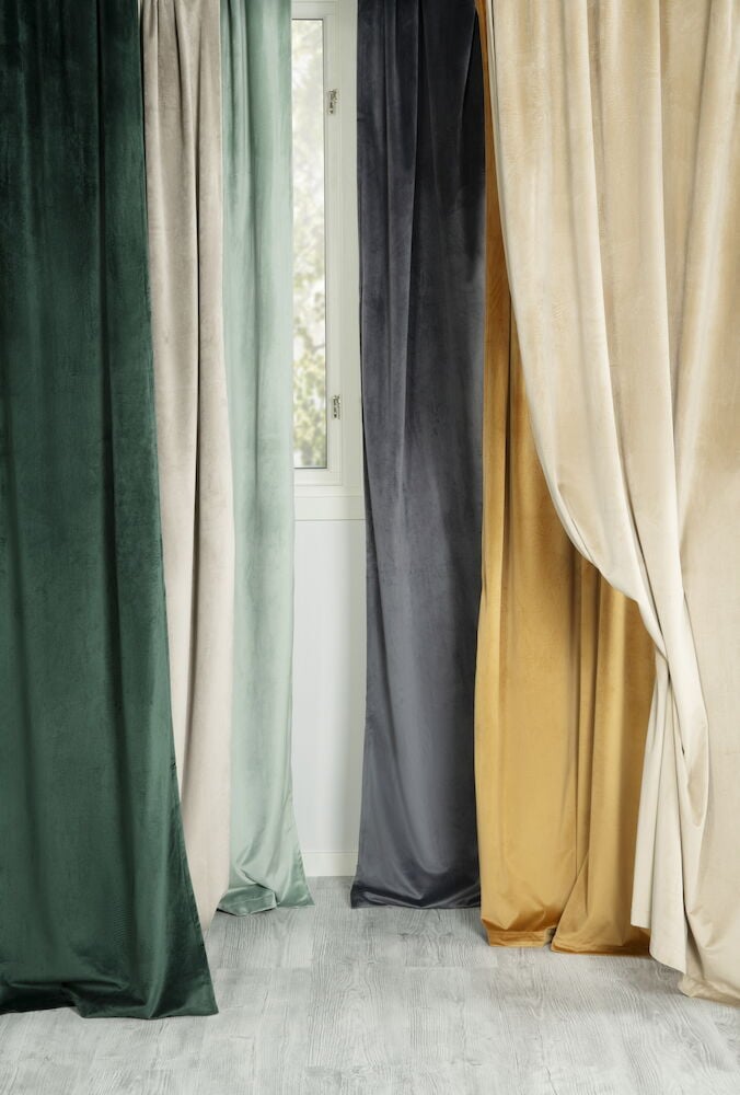 Flera sammetsgardiner i olika färger framför fönster.