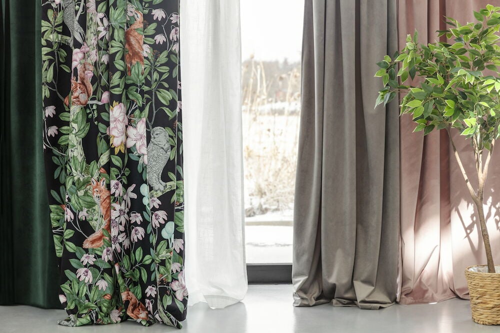 Vaaleanpunainen samettiverho ikkunassa luonnonvalon kanssa.