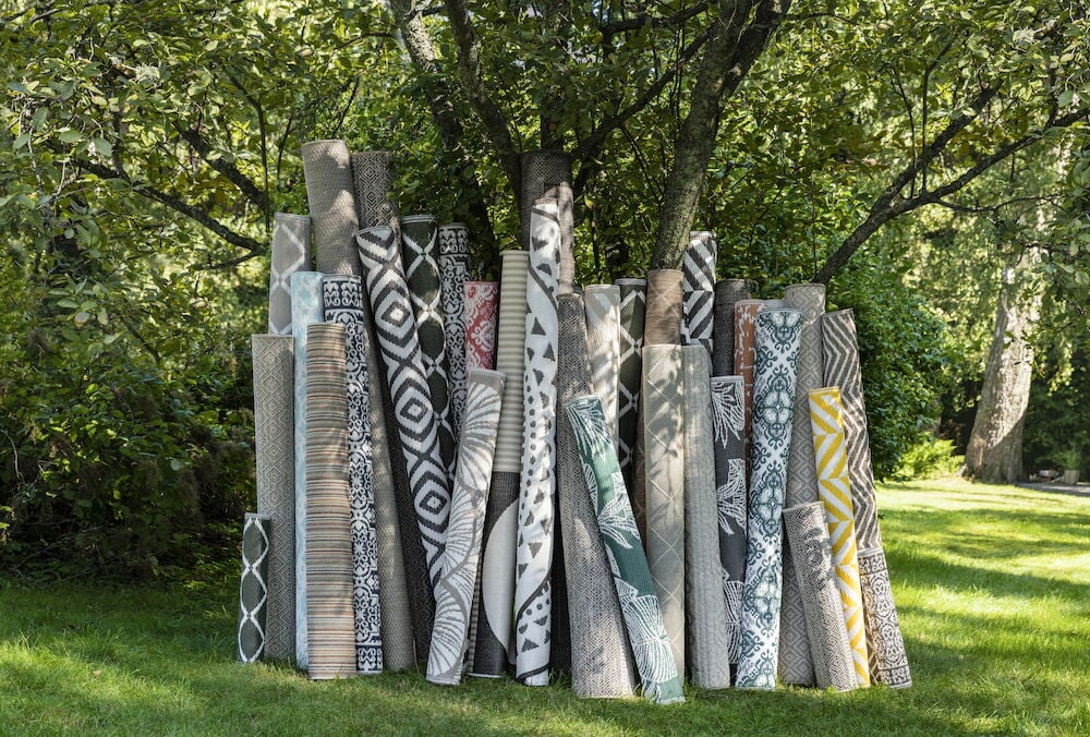 Grå bastmatta med dekorativt mönster för utomhusbruk.