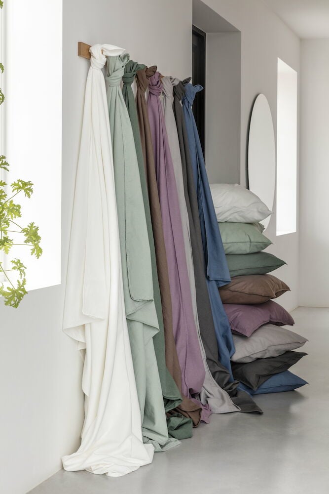 Olika färger av påslakanset hänger på väggkrok.