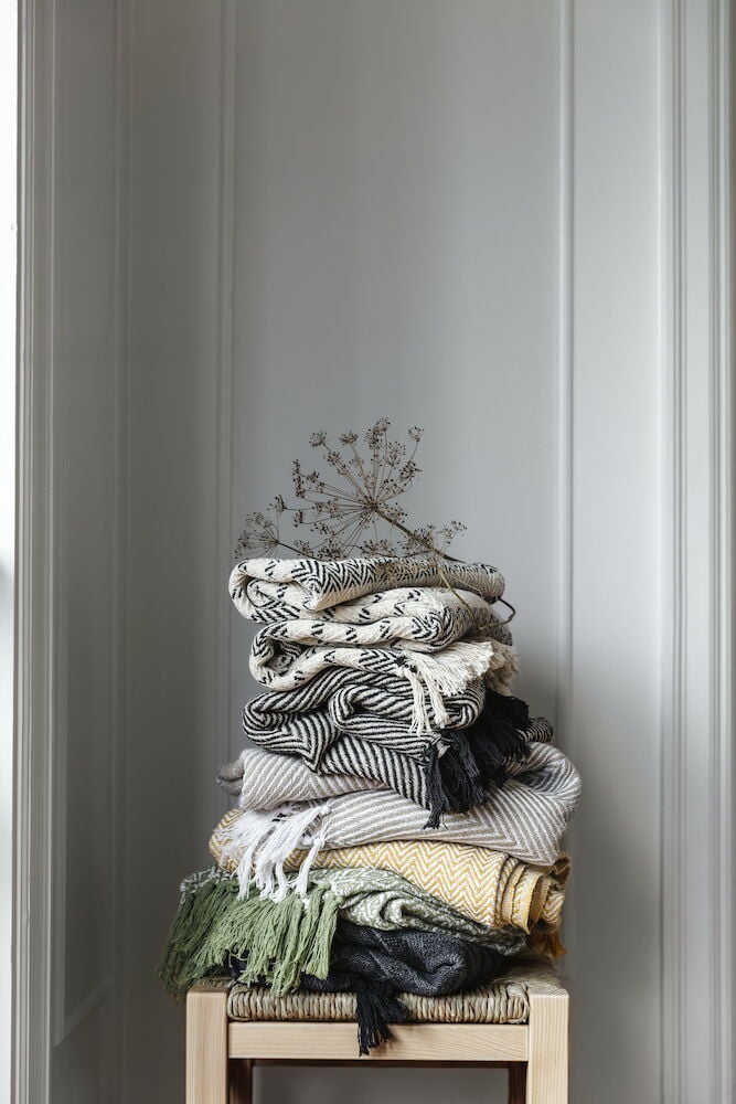 Pläd i off-white bomull på soffa