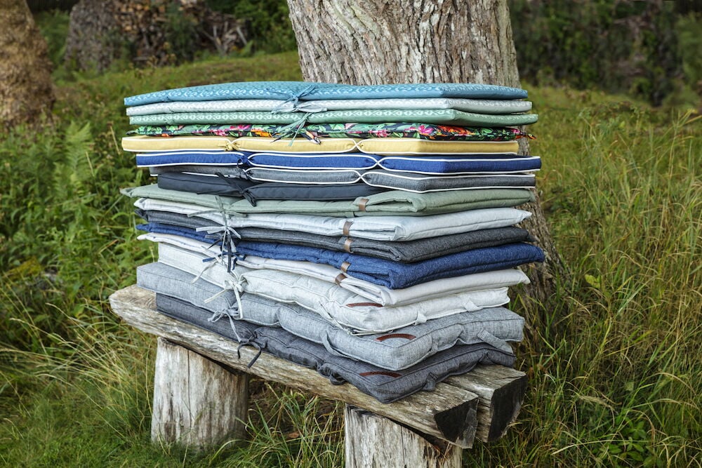 En stapel dynor i olika färger utomhus.