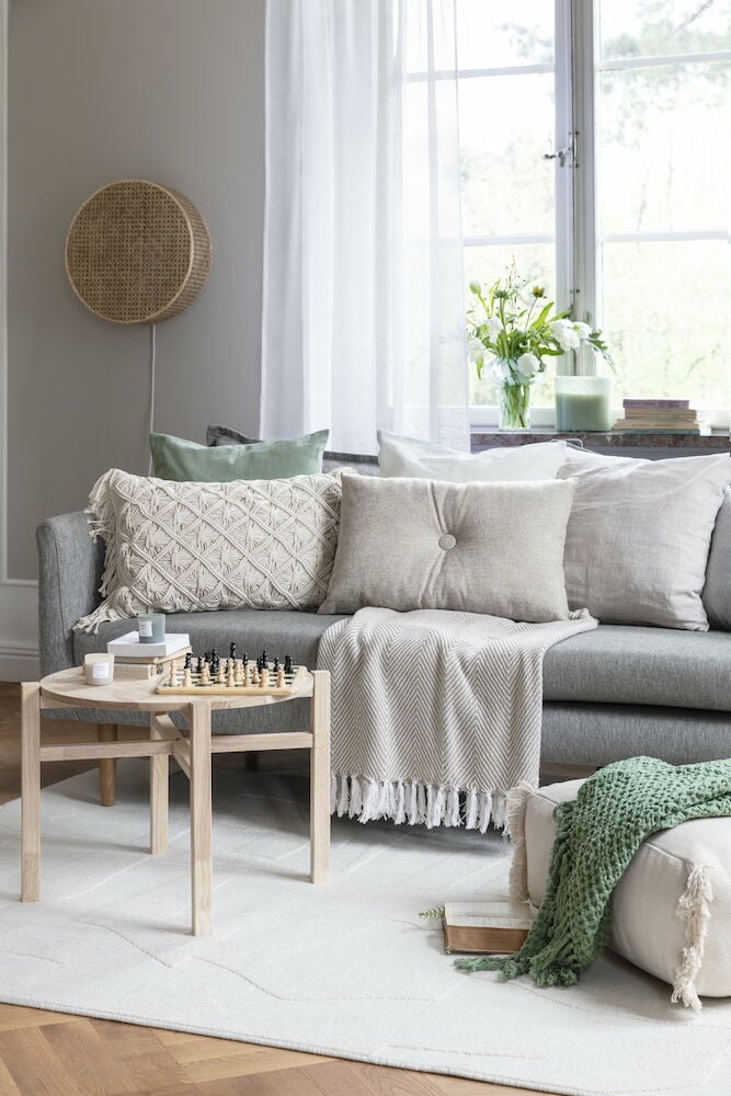 Neljä tuoksukynttilää lasisessa purkissa olohuoneen sohvapöydällä.