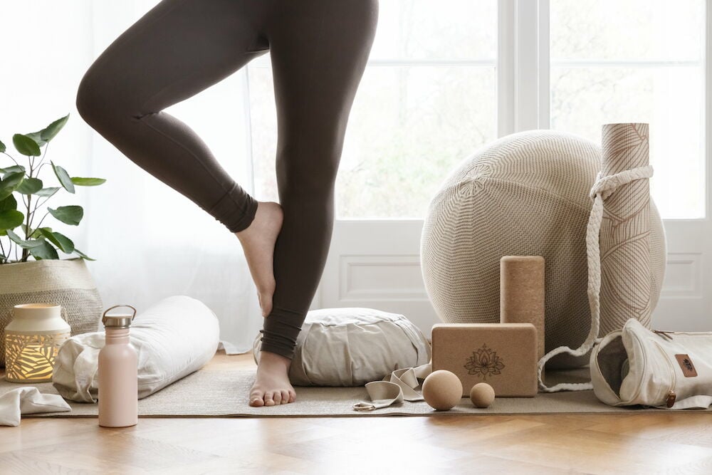 Meditationskudde och yogautrustning på yogamatta inomhus.