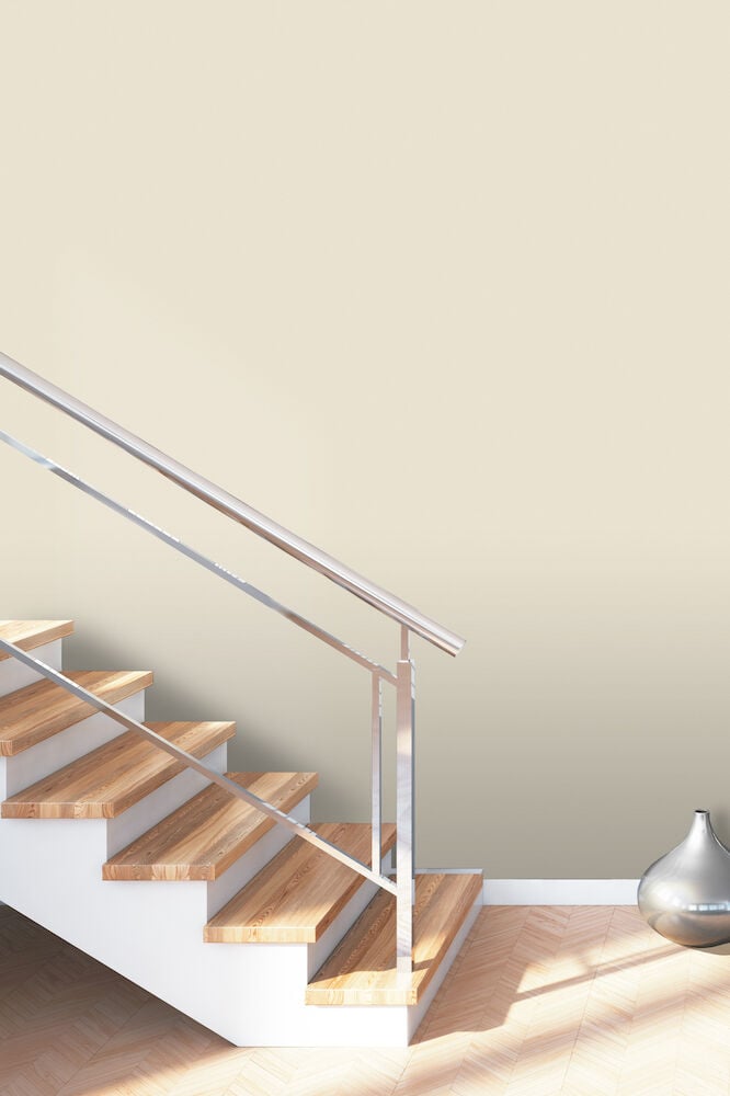 Ljusbeige tapet på vägg vid trappa och vas.